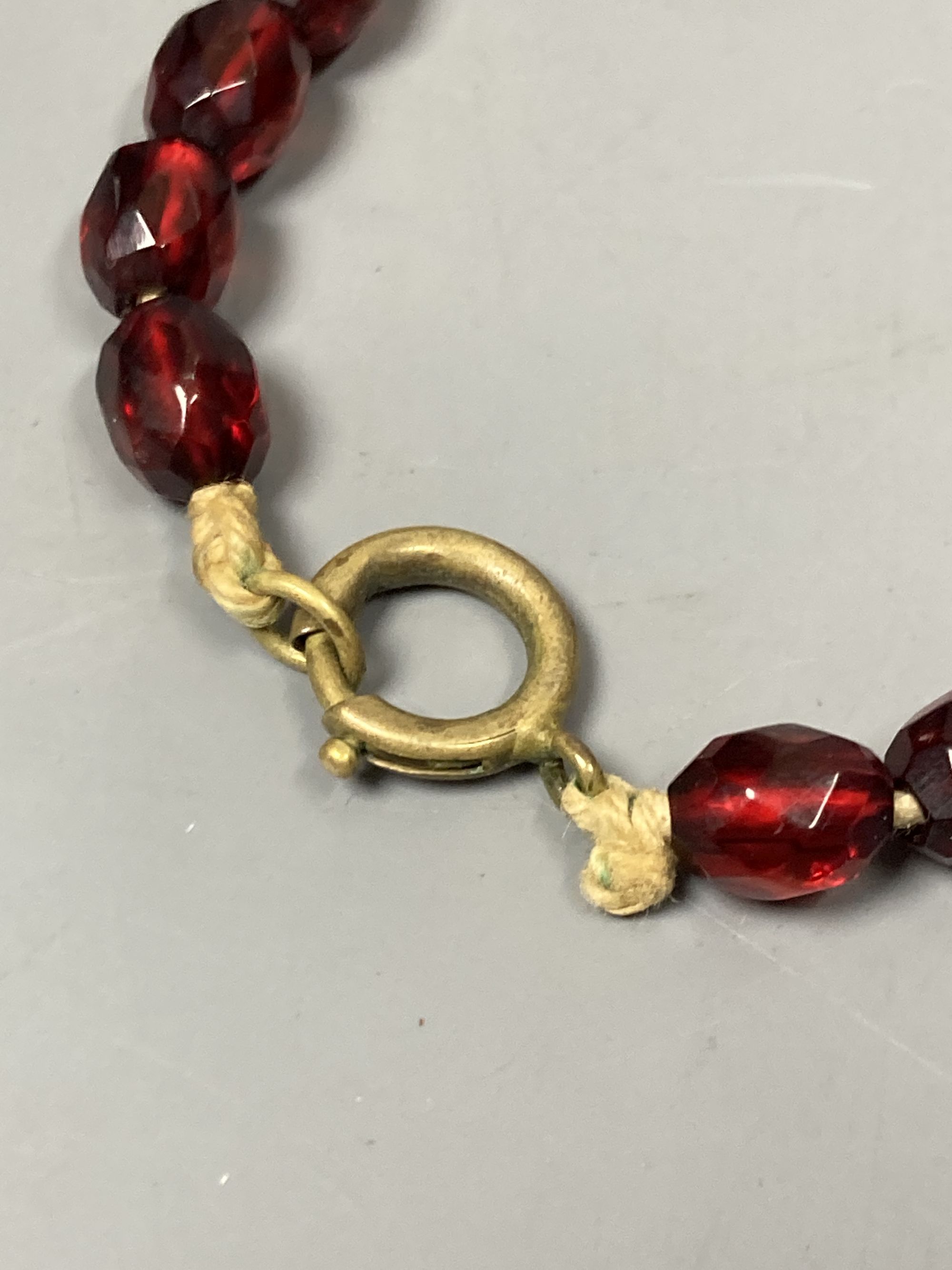 Two transluscent single strand simulated cherry amber bead necklaces, longest 82cm, gross weight 120 grams.